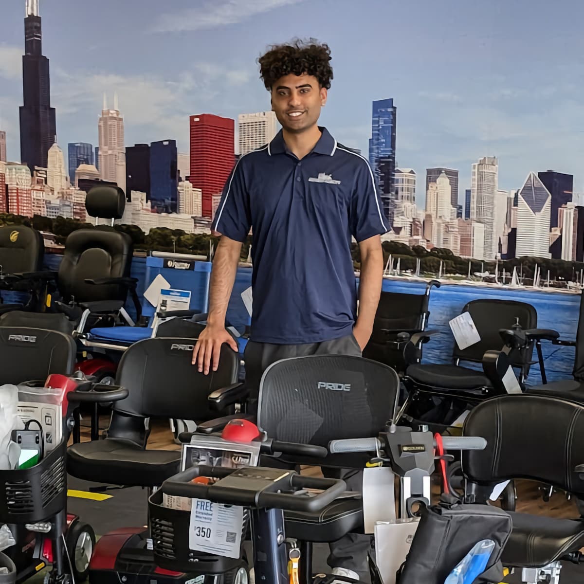 Moses; Midwest Mobility's Sales Manager. Smiling young man in showroom surrounded by scooters